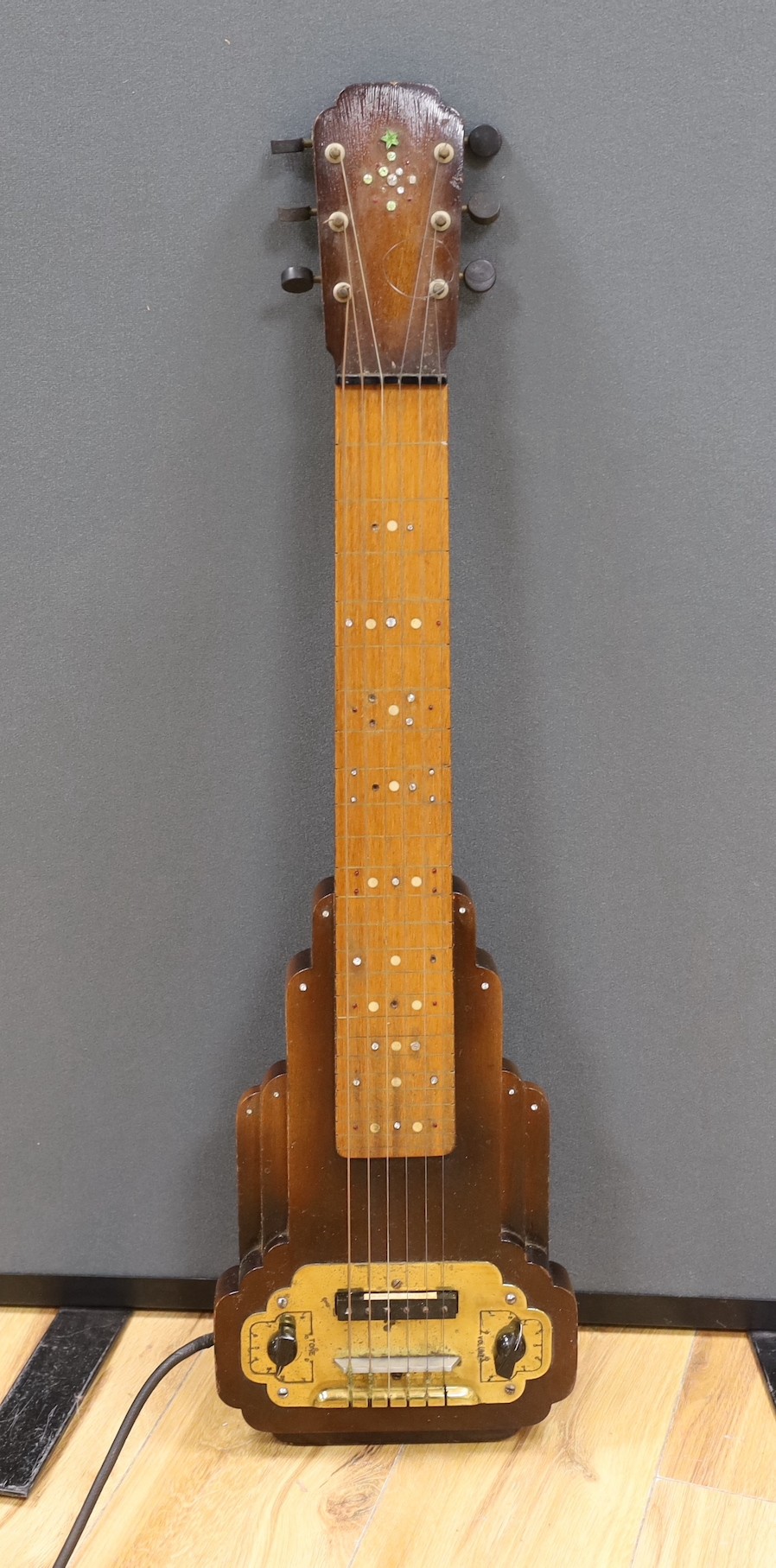 A steel guitar, the case, inscribed Haiwaians, 83cms high